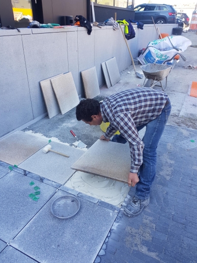 Plaatsen tegels in mortelbed van witte cement